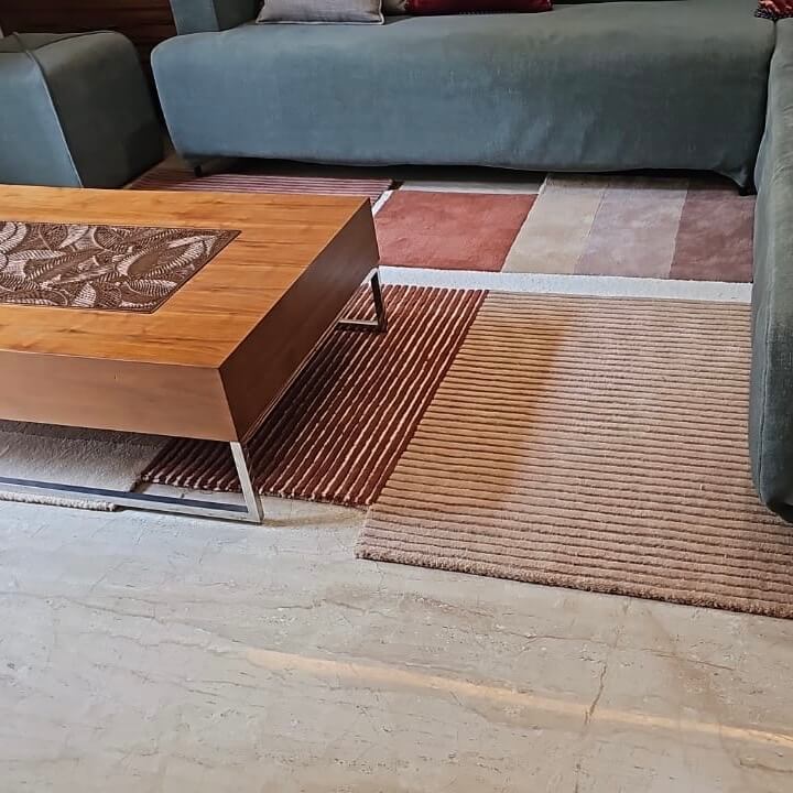 patterned wool rug in a living room with a wooden coffee table and sofa
