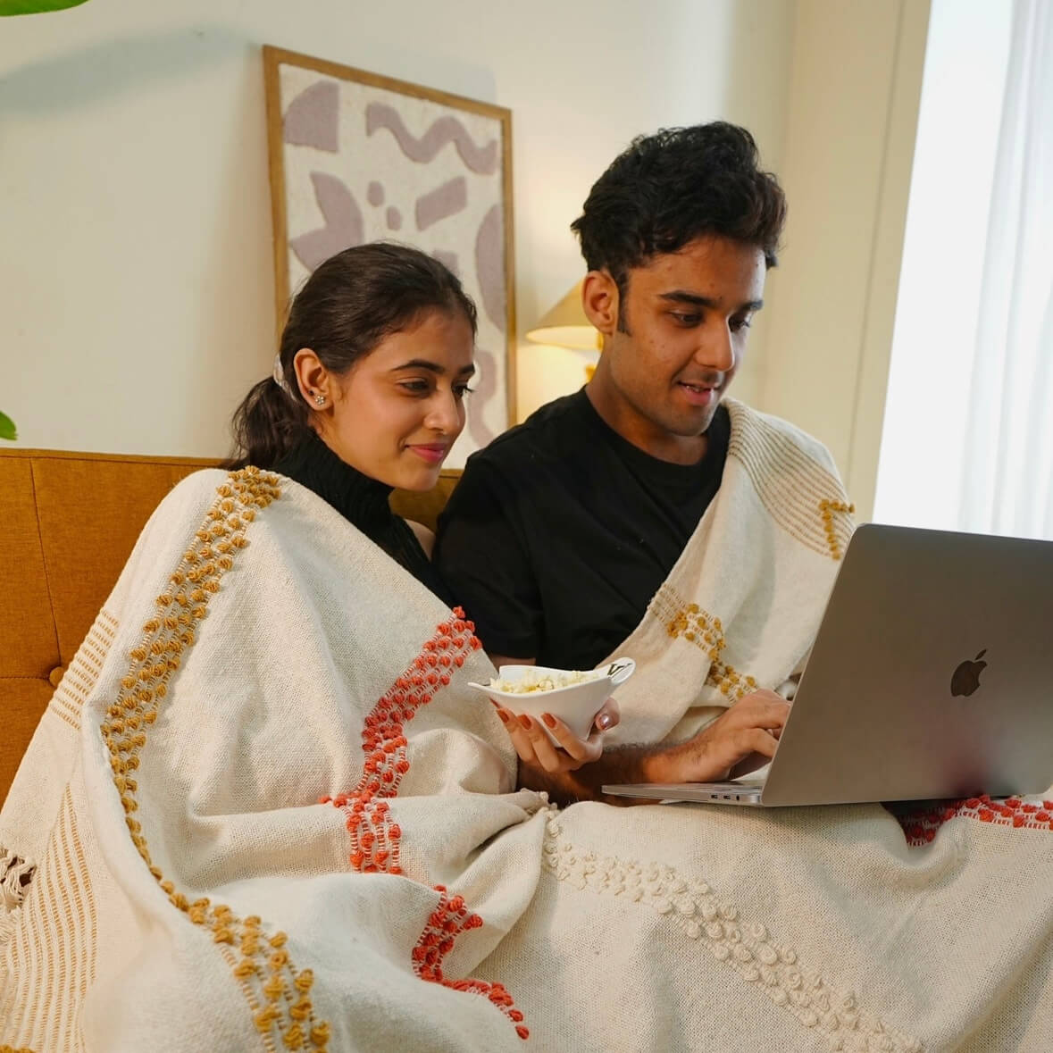couple sitting together with cotton throw banket