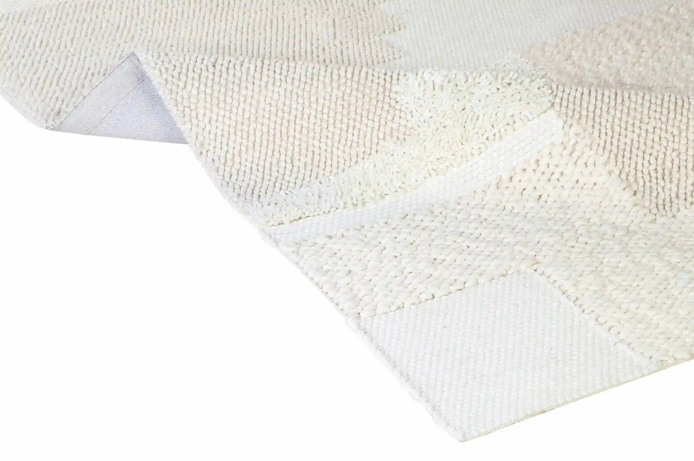 Close-up of a textured white rug corner