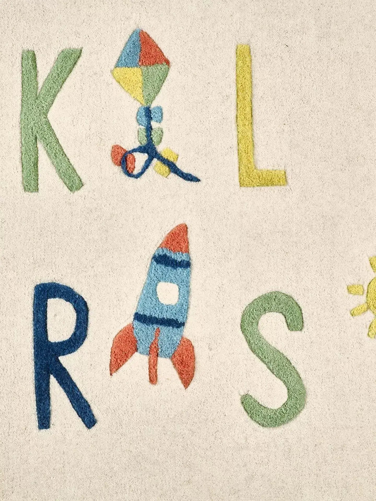 kids room wool rug with colorful letters and a kite, rocket, and sun design.