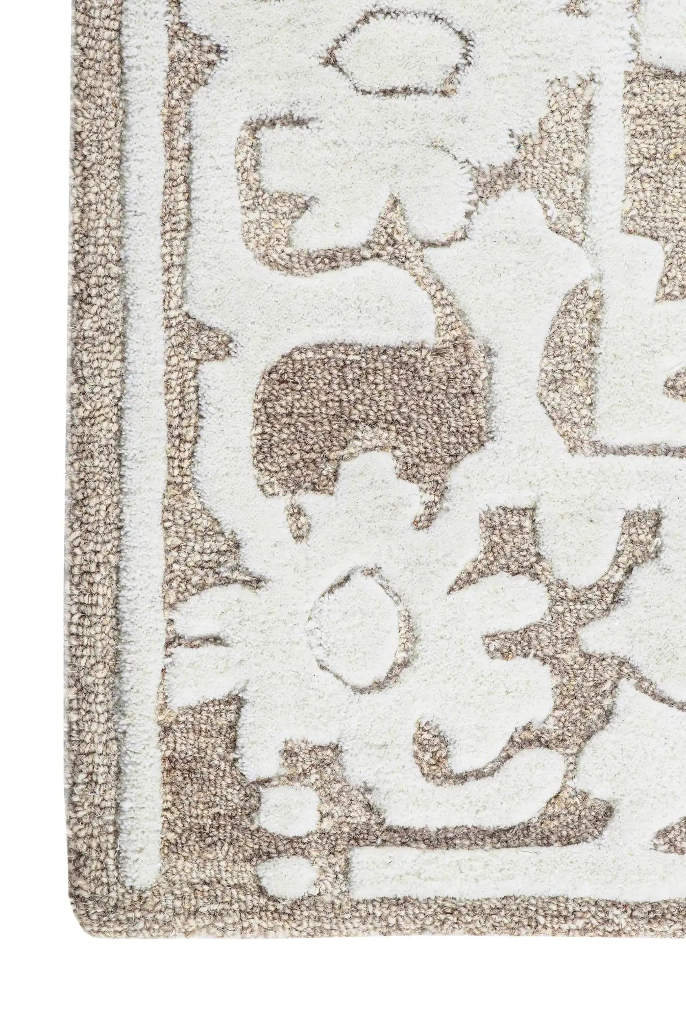 Close-up of a textured wool rug with floral patterns in beige and white.