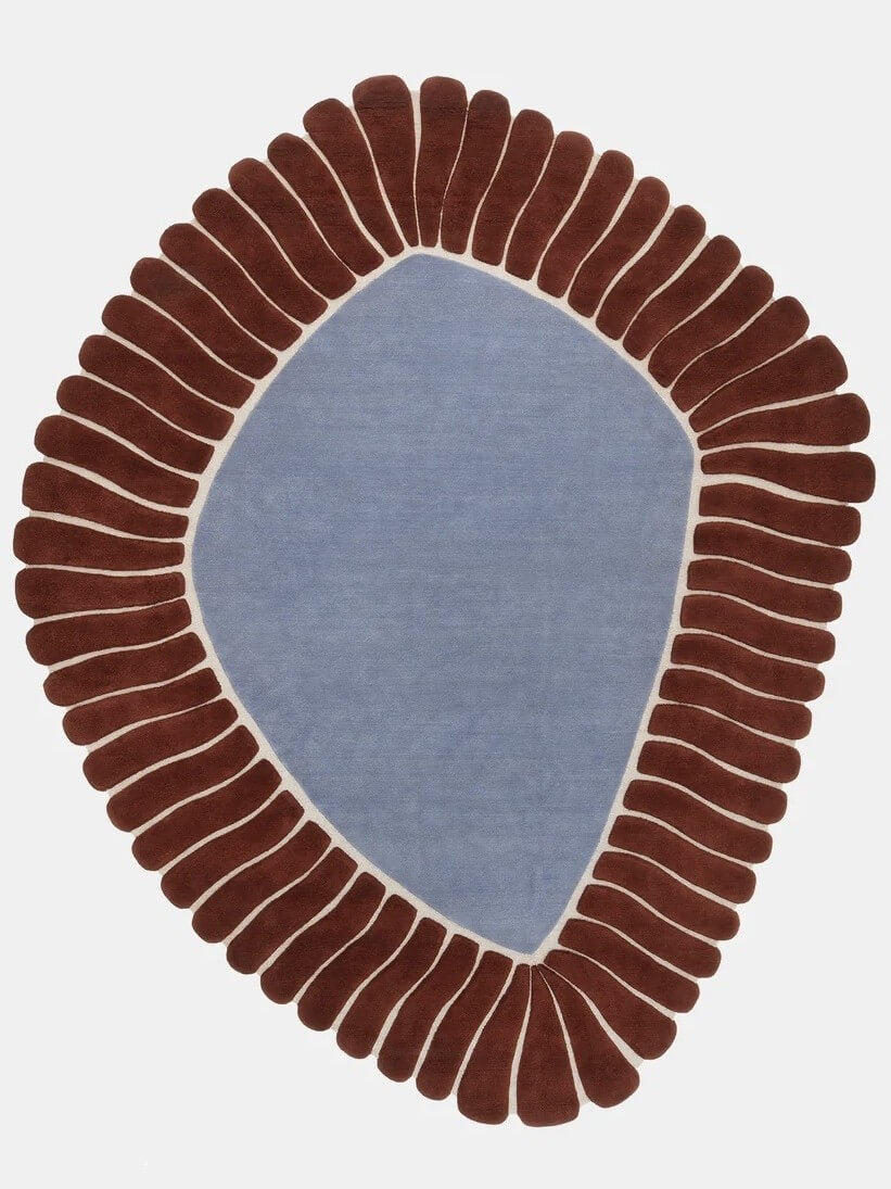 An abstract oval shaped area rug, hand tufted with NZ wool